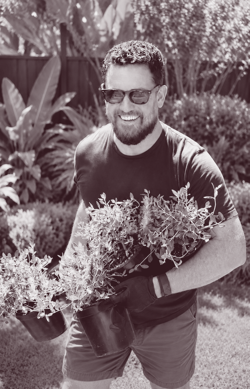 Gareth Walker carrying new plants through a garden during installation